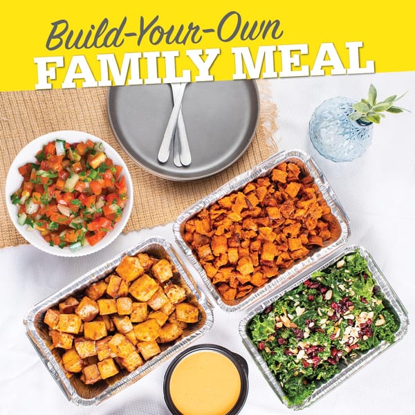 Overhead view of a "Build-Your-Own Family Meal" with various dishes in foil containers.