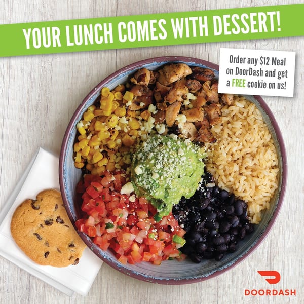 A colorful burrito bowl with chicken, rice, corn, salsa, black beans, guacamole, and a chocolate chip cookie.